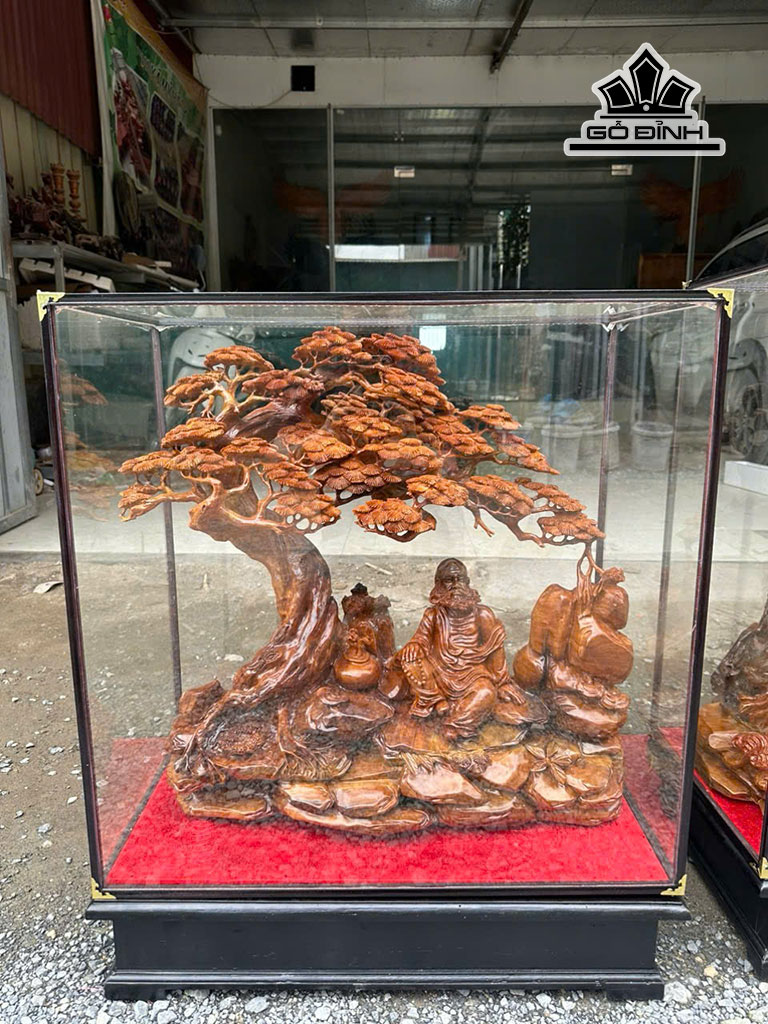 Tượng Đạt Ma Ngự Gốc Tùng Gỗ Ngọc Am Cao 67 Ngang 68 Sâu 25 (cm) - Cả Tủ Kính Cao 85 Ngang 72 Sâu 40 (cm)