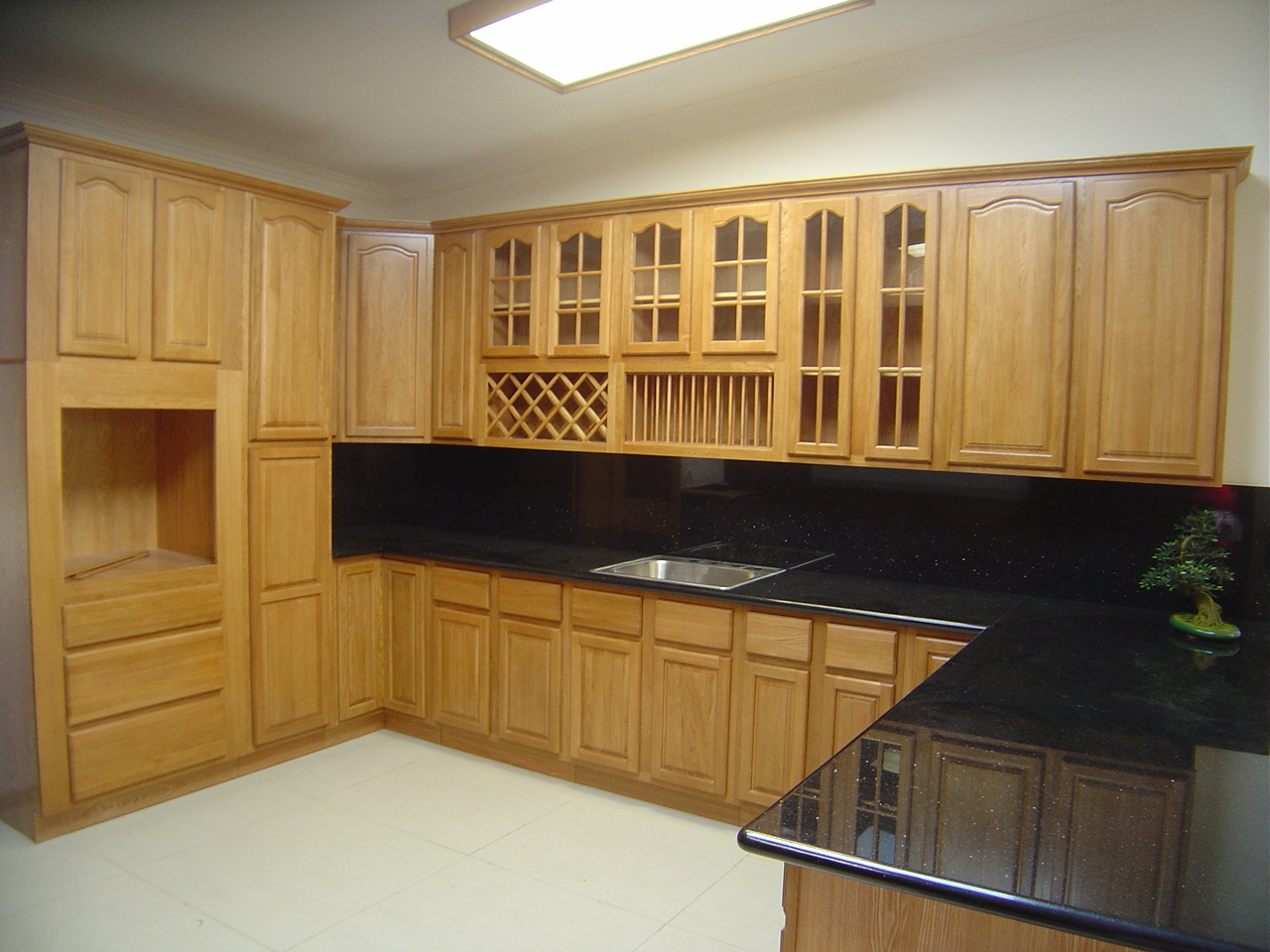 Tủ bếp gỗ sồi (Oak) hình chữ L được bao trùm bởi tone màu vàng nhạt đem đến vẻ đẹp mộc mạc và tiện nghi cho không gian phòng bếp
